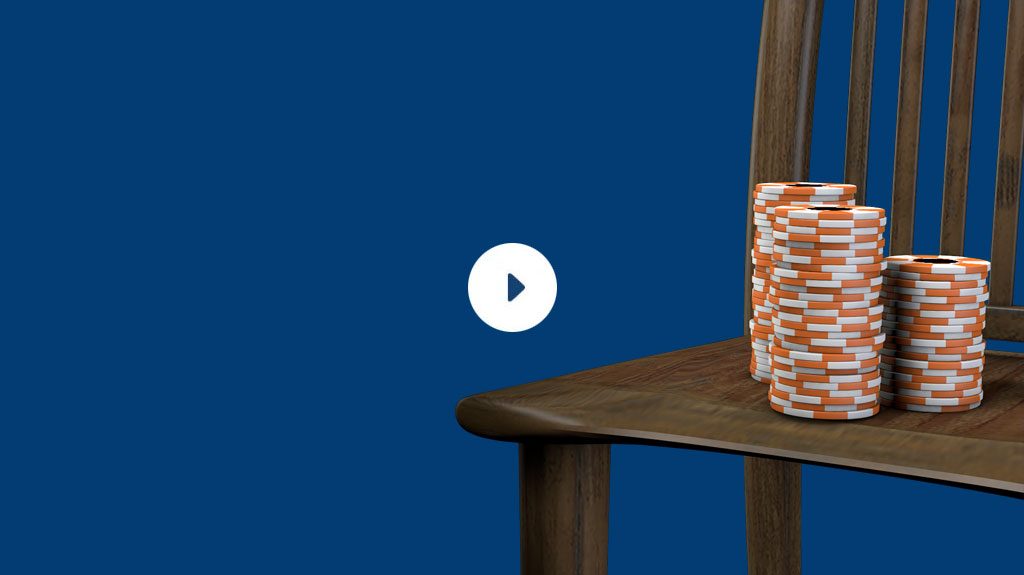 Poker chips sitting on a wooden chair.