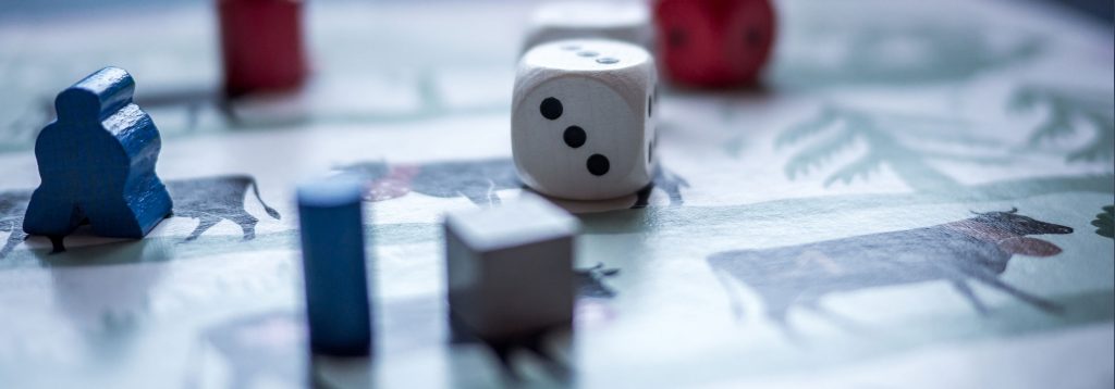 Dice and wooden game pieces on an “antique” game board