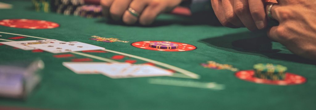 Hands of two gentlemen playing blackjack.