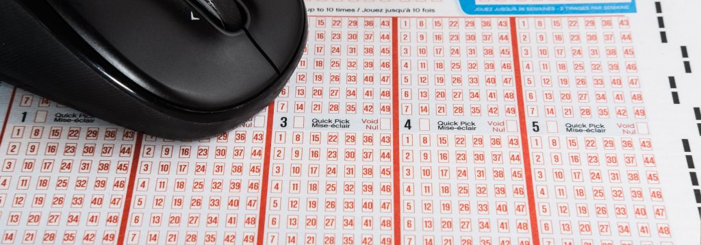 A computer mouse sits on top of a lottery selection slip.