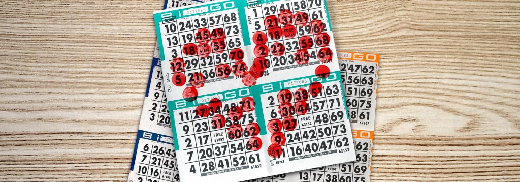 Une pile de cartes de BINGO avec des marques de tampon qui forment un cœur