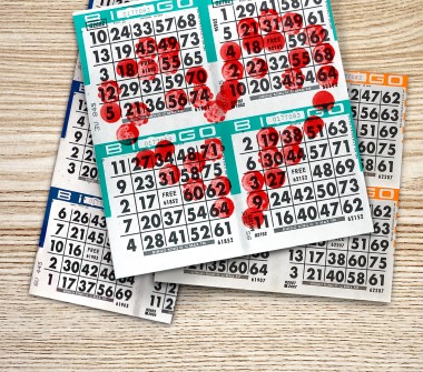 Une pile de cartes de BINGO avec des marques de tampon qui forment un cœur
