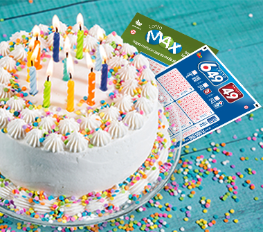 A birthday cake with lit candles on a table with Lotto Max and Lotto 6/49 selection slips.