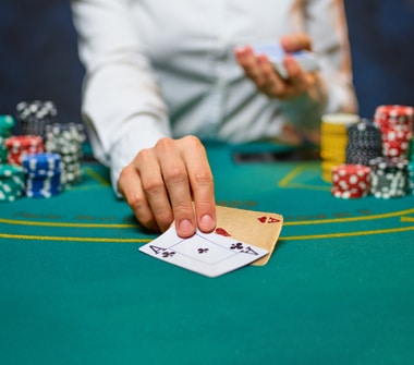 A hand holding two playing cards, one new and the other old.