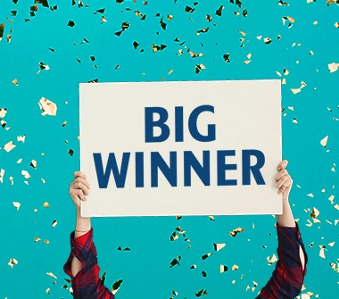 A sign that reads BIG WINNER is held up by a person.