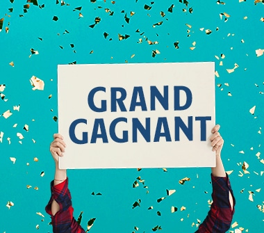 Une affiche sur laquelle est inscrite « GRAND GAGNANT » est tenue en l’air par une personne.