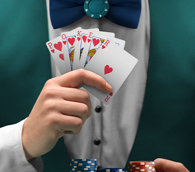 Casino dealer with poker chips and holding up a suit of cards.